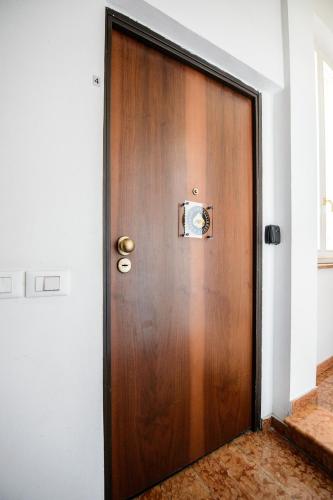 a wooden door with a brass knocker on it at PINK HOUSE TORTELLINOSUITE Modena in Modena