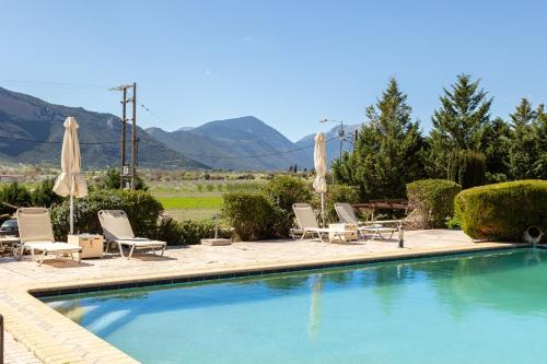 uma piscina com cadeiras e guarda-sóis em Pleiades All Season Gems - Korinthos Stone Retreats em Kalianoi