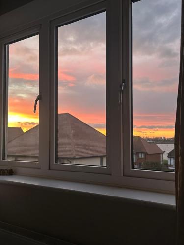 a window with a view of a sunset at Luxury HomeStays - Hot Tub - Sea Views - Sleeps 8 in Portsmouth