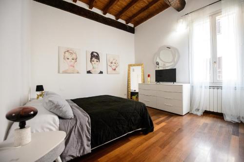 a bedroom with a bed and a dresser and a mirror at PINK HOUSE TORTELLINOSUITE Modena in Modena