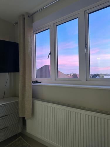 a bathroom with three windows with a view of the desert at Luxury HomeStays - Hot Tub - Sea Views - Sleeps 8 in Portsmouth