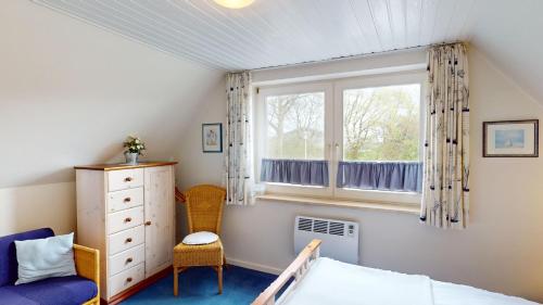a bedroom with a bed and a window at Gollendorf "Vier Pfoten" in Fehmarn