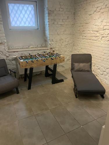 a room with a foosball table and two chairs at Apartament Wspólna in Sosnowiec