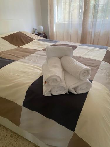 two white towels are stacked on a bed at B&B POSEIDON in Fiumicino