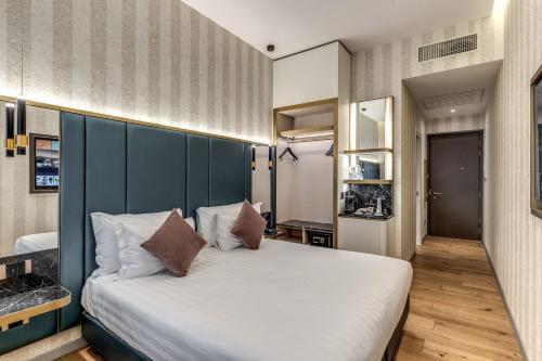 a bedroom with a large bed with a blue headboard at CC Palace Hotel in Rome
