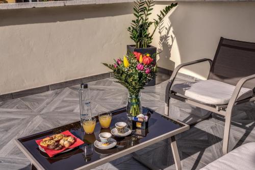 a table with a vase of flowers and a plate of food at CC Palace Hotel in Rome