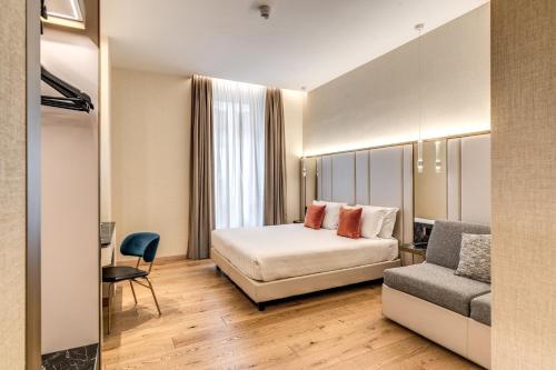 a hotel room with a bed and a chair at CC Palace Hotel in Rome
