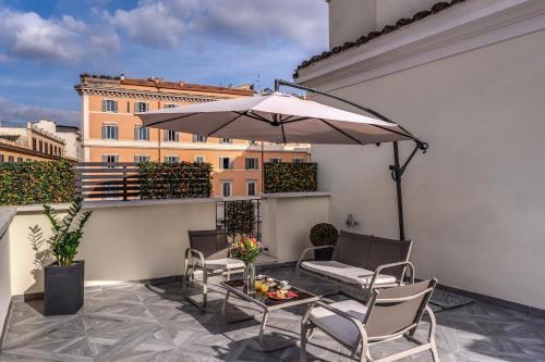 a patio with a table and an umbrella on a balcony at CC Palace Hotel in Rome