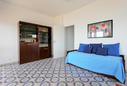 a bedroom with a blue bed and a kitchen at Mare Fuori in Nettuno