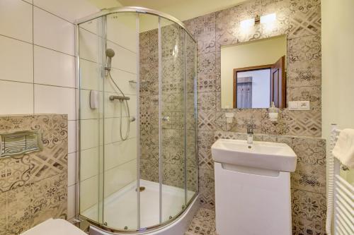 uma casa de banho com um chuveiro e um lavatório. em Penzión Čerešňový Sad & Wellness em Mengusovce
