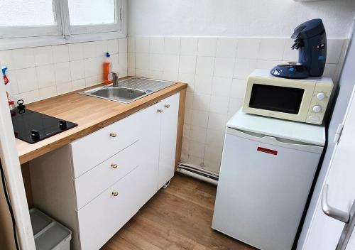 une petite cuisine avec un micro-ondes et un évier dans l'établissement 1# Central'Tours VERT, à Tours