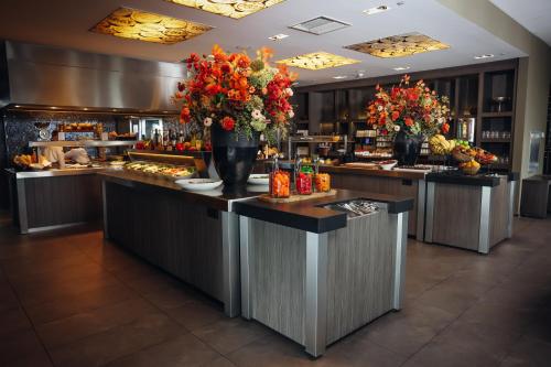 a buffet line in a restaurant with flowers on the counter at Van der Valk Hotel Dordrecht in Dordrecht