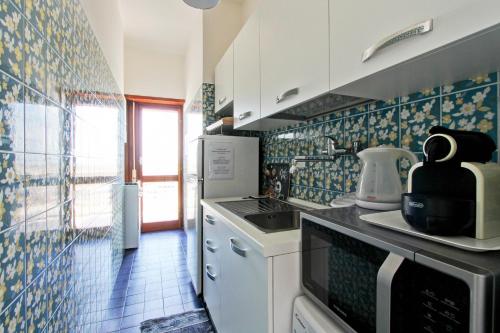 a kitchen with blue and white tiles on the wall at Mare Fuori in Nettuno