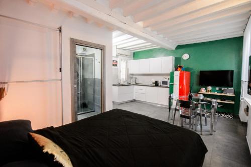 a room with a bed and a kitchen with a refrigerator at ITALIA HOUSE TORTELLINOSUITE Modena in Modena