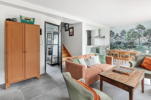 ein Wohnzimmer mit einem Sofa und einem Tisch in der Unterkunft LA BAIE - Belle maison de charme -Jardin/Parking in Cancale