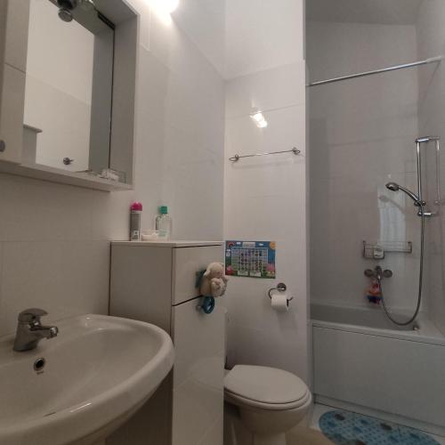 a white bathroom with a toilet and a sink at Suntime villa Laguna in Bigova
