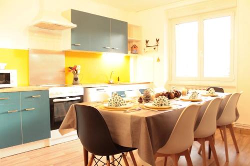 une cuisine avec une table et des chaises dans une cuisine dans l'établissement L'Aparté - Cosy corner, à Bussang