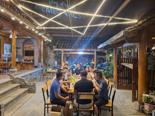 a group of people sitting at a table in a restaurant at MeoVac Ethnic Homes in Mèo Vạc