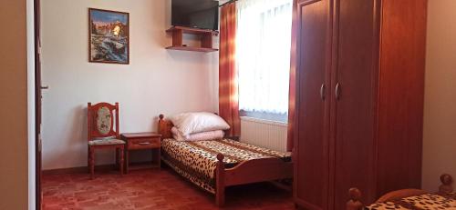 Habitación pequeña con silla y ventana en Pokoje Gościnne ADA, en Jeleniewo