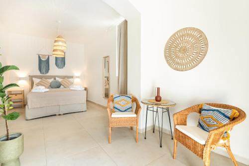een slaapkamer met een bed en stoelen en een tafel bij Camara Residence in Chania