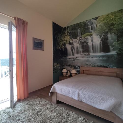 a bedroom with a waterfall mural on the wall at Suntime villa Laguna in Bigova