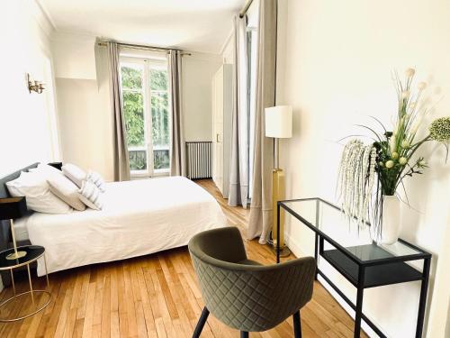 a bedroom with a bed and a desk and a chair at Grand appartement d'exception au Château Randin in Écully