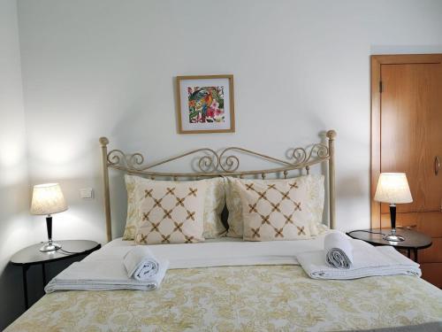 ein Schlafzimmer mit einem großen Bett mit zwei Nachttischen in der Unterkunft Casinha do Sossego in Melgaço