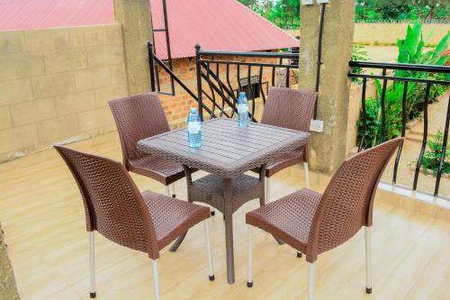 - une table et des chaises avec des bouteilles d'eau sur la terrasse dans l'établissement NB MOTEL-KIHIHI, à Kihihi