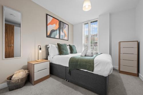 um quarto com uma cama grande e uma janela em One Cambridge Residence by COQOON em Manchester