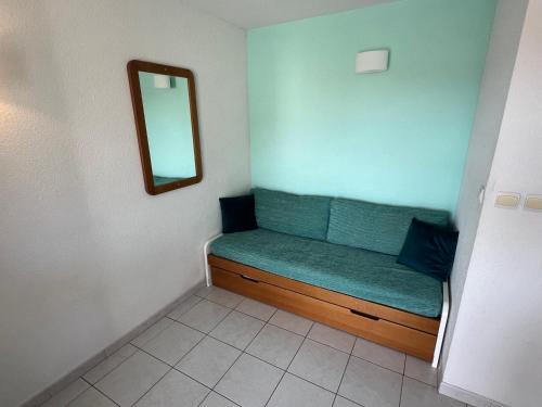 Cette petite chambre comprend un banc vert avec un miroir. dans l'établissement PRIMAVERA Agréable T2 résidence avec piscine Plage Richelieu Cap d'Agde, au Cap d'Agde