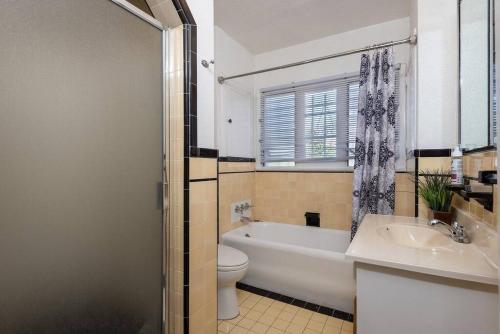 a bathroom with a tub and a toilet and a sink at Serenity in the City: 2BR Apartment w/ Hot Tub in Los Angeles