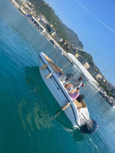 a white boat floating in the water near a beach at Cbrentboatsalerno in Salerno