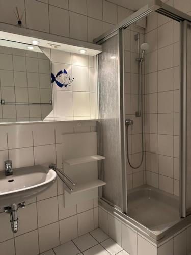 ein Bad mit einer Dusche und einem Waschbecken in der Unterkunft Ferienhaus Heyder in Norderney