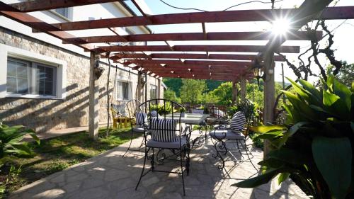 a patio with chairs and a wooden pergola at Casa DaFin Tekija - Kladovo in Tekija