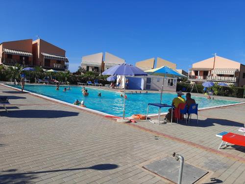 a large swimming pool with people in a resort at Casa Vacanze Isabella in Campofelice di Roccella