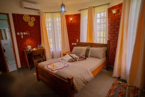 a bedroom with a bed with two dolls on it at Boloti Camp resort in Lemira