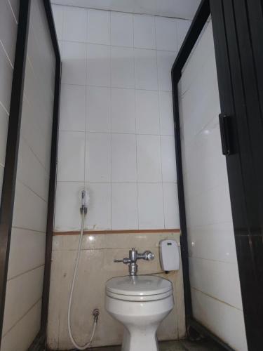 ein kleines Bad mit einem WC und einem Spiegel in der Unterkunft Harys house in Padurenan