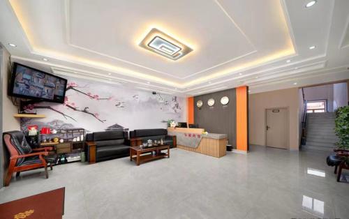 sala de estar con sofá y TV en Hongge Hotel - Harbin Taiping Airport, en Harbin