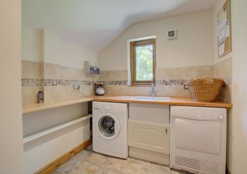 eine Küche mit einer Waschmaschine und einem Waschbecken in der Unterkunft Ruston Lodge in Thursford