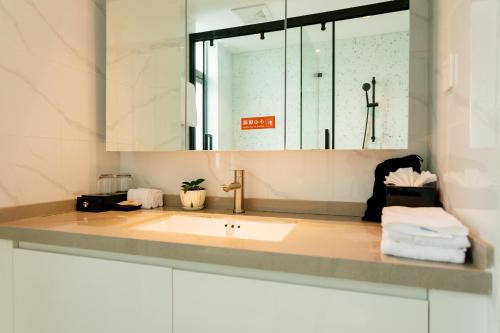 a bathroom with a sink and a mirror at The Q Residence Vientiane in Vientiane