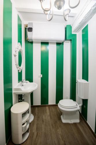 a green and white bathroom with a toilet and a sink at PADDINGTON TORTELLINOSUITE Modena in Modena