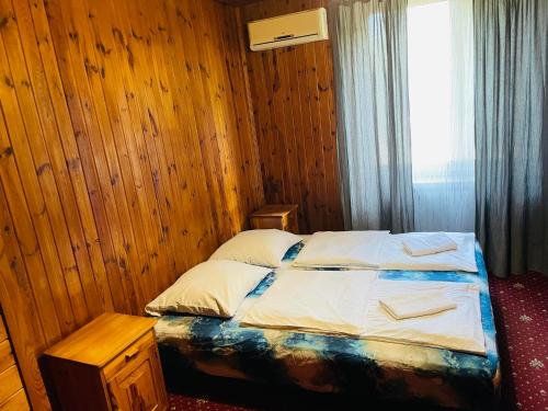 a bed in a wooden room with a window at Green House in Wola Przypkowska