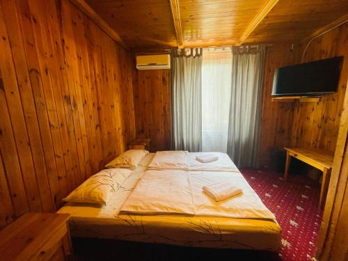 a bedroom with a bed in a wooden room at Green House in Wola Przypkowska