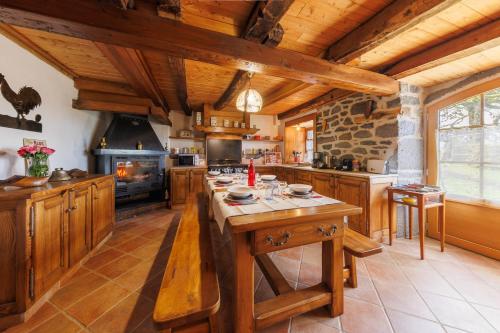 une grande cuisine avec des placards en bois et une table en bois dans l'établissement L'Anglardoise - Maison pour 7 voyageurs, à Anglards-de-Salers
