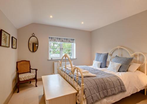 een slaapkamer met een bed, een stoel en een raam bij Alcocks Cottage in Syderstone