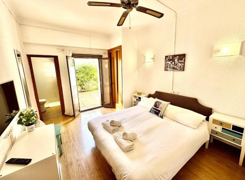 een slaapkamer met een wit bed en handdoeken bij Hotel Marbel in Cala Ratjada