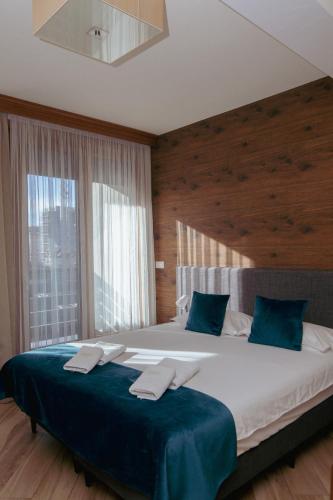 a bedroom with a large bed with blue pillows at Central Inn in Zlatibor
