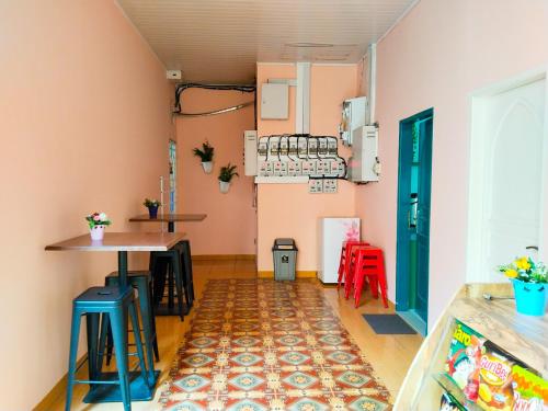 Habitación con paredes rosas, mesa y taburetes en Grand Shaqilla Syariah, en Delitua