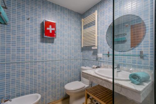 a blue tiled bathroom with a toilet and a sink at Templo cota 2330m in Sierra Nevada