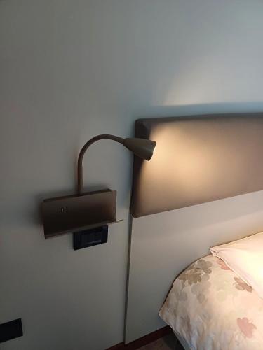 a lamp on a wall next to a bed at La Casa di Linda in Mirano